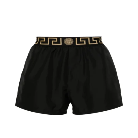 Versace Greca Border Swim Shorts in black, featuring an elasticated waistband with the signature Greca border and Medusa motif, designed for both style and comfort, available at Lestyle Boutique.